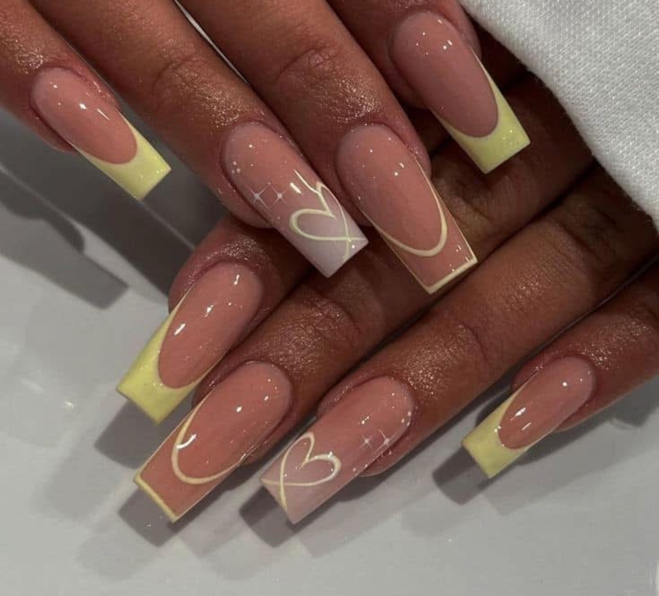 Yellow French tip nails with heart details